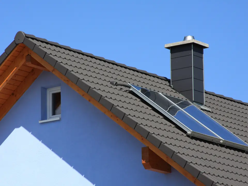 New grey tiled roof with a chimney and roof window