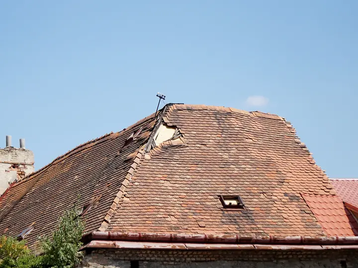 Tiled roof with a hole torn in it