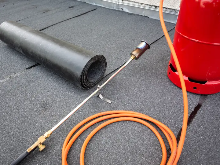 Felt roll and gas torch on a flat roof