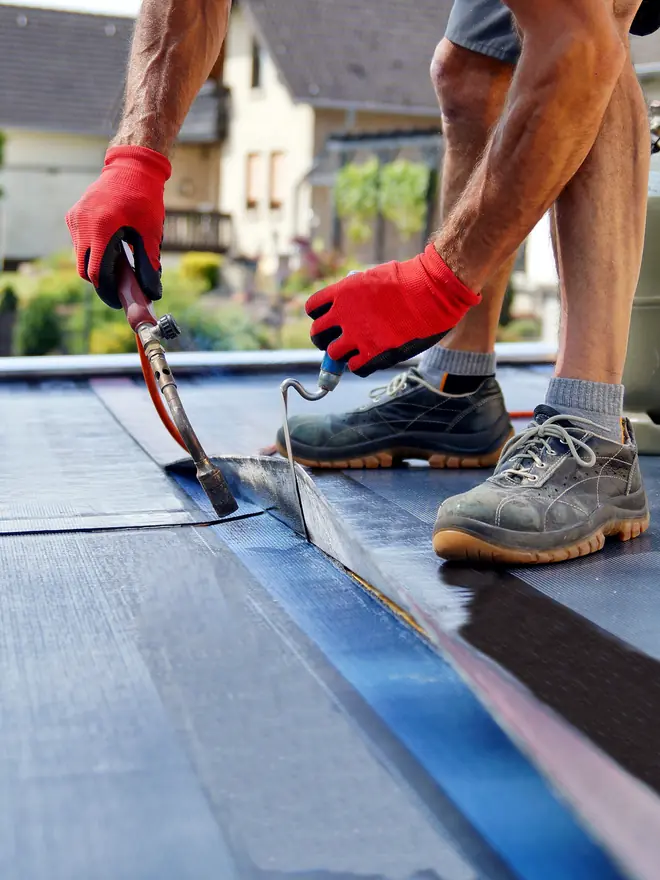 Roofer torching on a felt flat roof