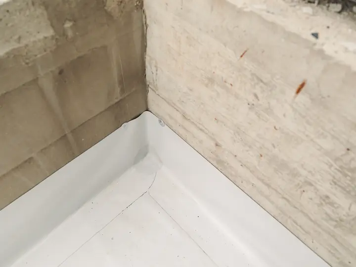 Single-ply flat roof membrane dressed into a corner upstand