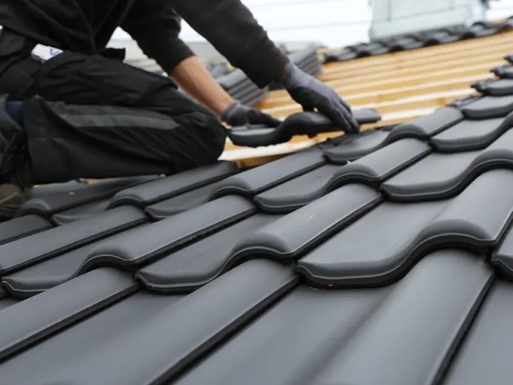 Roofer fitting new interlocking roof tiles