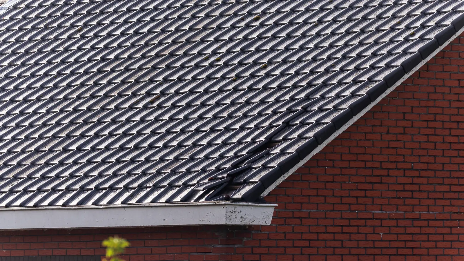 Dark tiled roof on a brick house