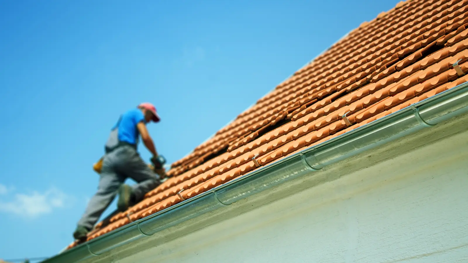 Roofer working on a clay tiled roof