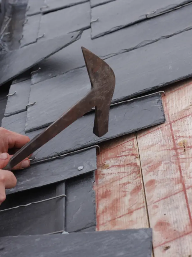 Roofer replacing a slate with a slate ripper