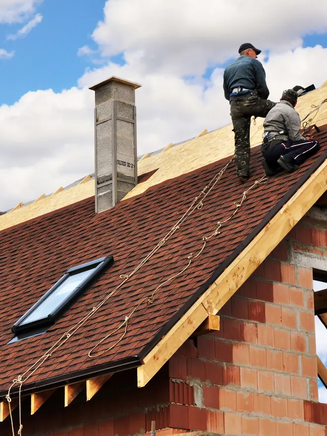 Roofers fixing a new tiled roof